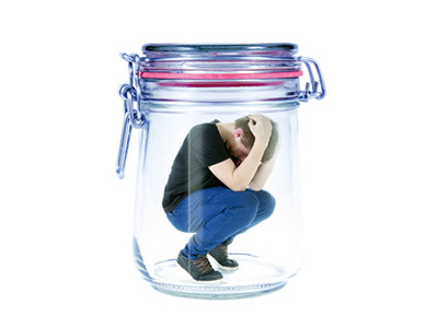 Ein Mann hockt in einem Einmachglas